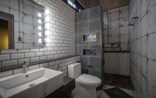 a bathroom with a white toilet and a sink at โรงแรม บอร์ดดิ้งเฮ้าส์ in Ban Bang Yai Chuai