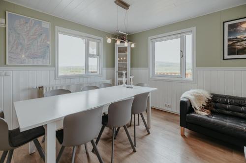 Brúnastaðir Holiday Home في Barð: غرفة طعام مع طاولة بيضاء وكراسي