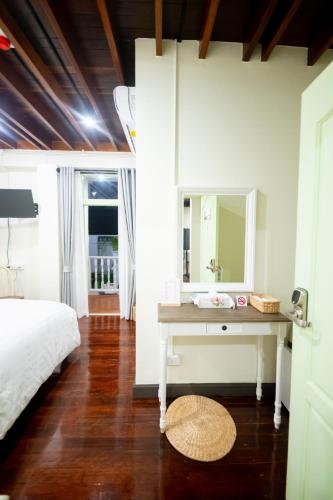 Una cama o camas en una habitación de Zane Balcony House Ranong Hotel เซน บัลโคนี่ เฮ้าส์ ระนอง