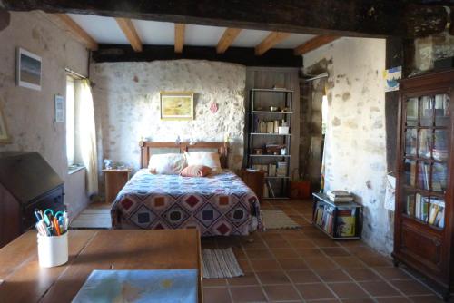 une chambre avec un lit et une étagère dans l'établissement Charmante maison du XVIIe siècle, à Came