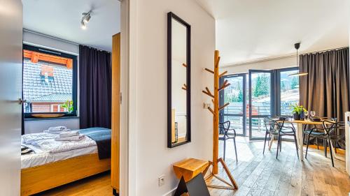ein Schlafzimmer mit einem Bett und ein Esszimmer mit einem Tisch in der Unterkunft Apartament Triventi 98 z Widokiem- 5D Apartamenty in Karpacz