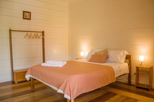 a bedroom with a bed with two lamps on it at Welfare AgroTurismo in Milagrosa