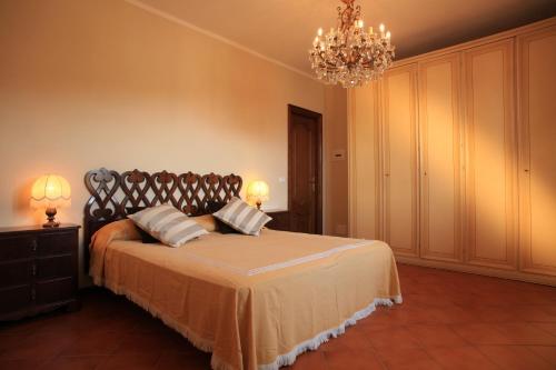 a bedroom with a large bed and a chandelier at Tenuta Domine in Imperia