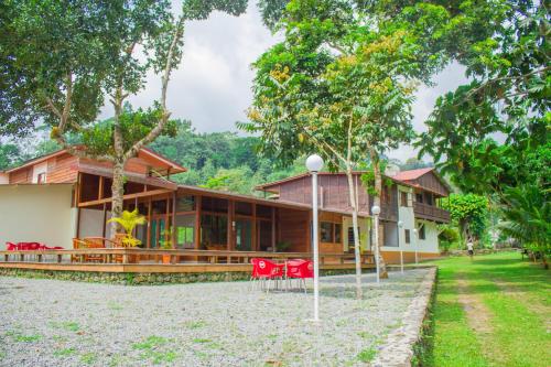 a house with red chairs in front of it at Welfare AgroTurismo in Milagrosa