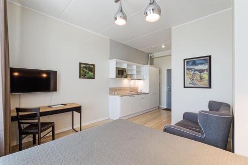 een kamer met een bed, een bureau en een keuken bij City Center Studio Apartment in Tallinn