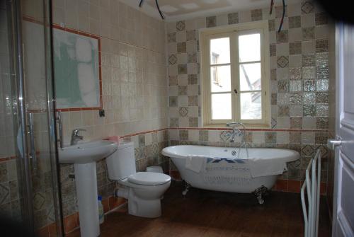 a bathroom with a tub and a toilet and a sink at La Petite Maison des Montagnes in Luz-Saint-Sauveur
