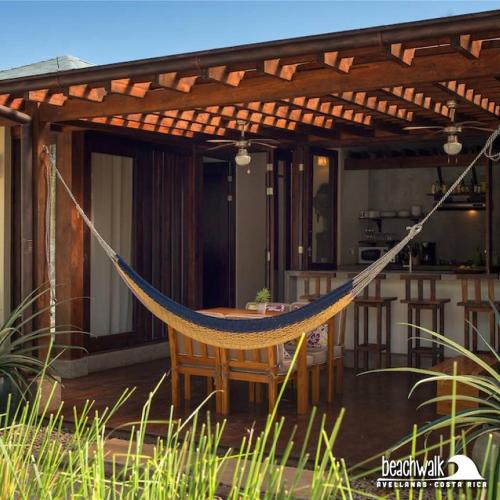 a hammock on the patio of a house at Beach Walk Costa Rica in Playa Avellana