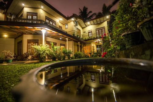 a house with a pool of water in front of it at Wildlife Safari House in Udawalawe