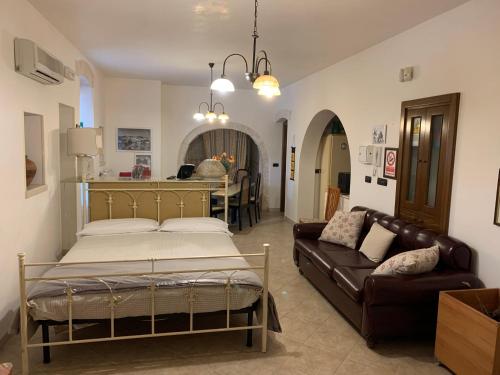 una camera con letto e divano di B&B Villa Grassi ad Alberobello