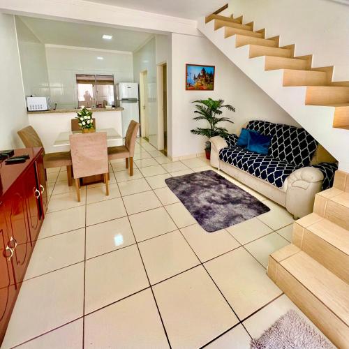 uma sala de estar com um sofá e uma escada em Nossa Casa, Sua Casa 01 - Excelente Localização em Paraty