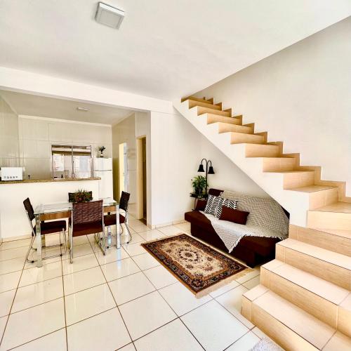 a living room with a staircase and a dining room at Nossa Casa, Sua Casa 02 - Excelente Localizacao in Paraty
