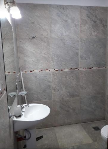 a bathroom with a white sink and a shower at La Chacarita apart in San Fernando del Valle de Catamarca