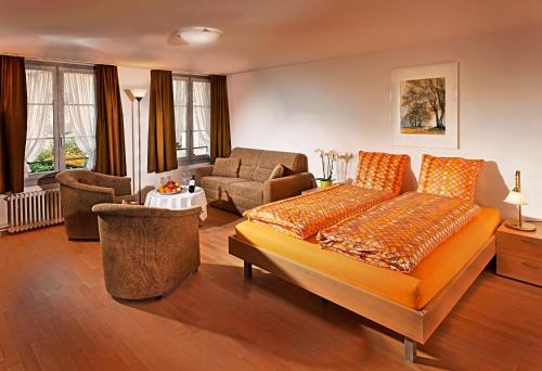 ein Schlafzimmer mit einem Bett und ein Wohnzimmer in der Unterkunft Ferienwohnungen Hotel Eden Spiez in Spiez