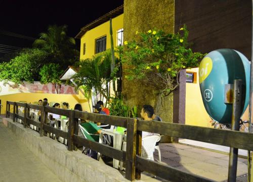 a group of people sitting at tables by a fence at Pousada Zabelê in São Raimundo Nonato