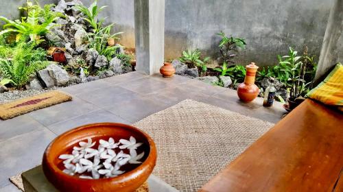 a bowl filled with white flowers sitting on a floor at Bindu Homestay in Wellawaya