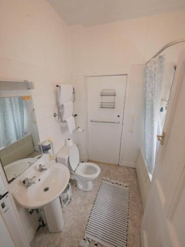 a bathroom with a white toilet and a sink at Bourne Hall Hotel in Bournemouth