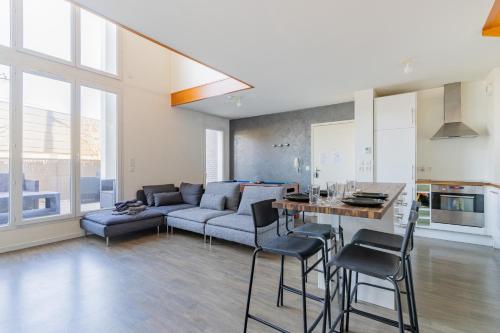 uma cozinha e sala de estar com um sofá e uma mesa em Urban Pool em Corbeil-Essonnes