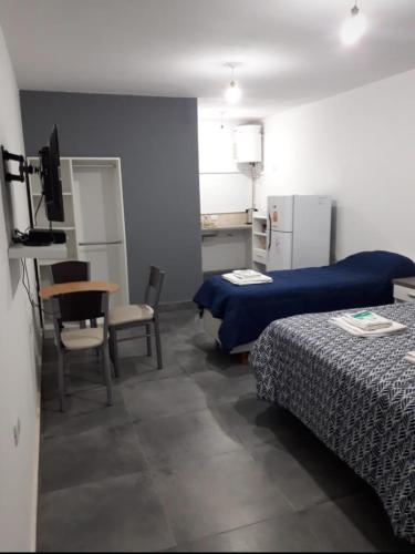 a hotel room with two beds and a table and chairs at La Chacarita apart in San Fernando del Valle de Catamarca