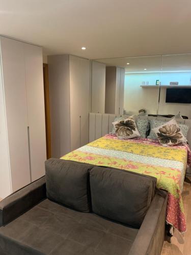 um quarto com uma cama grande e um sofá em Flat Life Resort com vista pra piscina/lago em Brasília