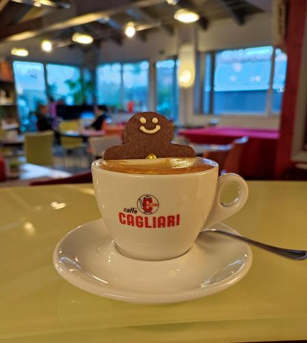 a cup of coffee with a cookie on top of it at Albergo Zoello Je Suis in Castelvetro di Modena
