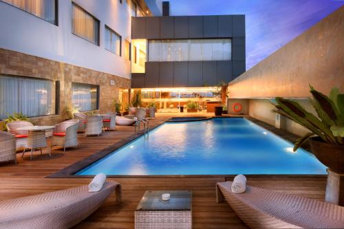 a pool in a hotel with chairs and a table at Swiss-Belhotel Harbour Bay in Nagoya