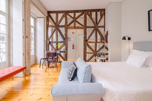 ein Schlafzimmer mit einem großen Bett und einem Sofa in der Unterkunft YOUROPO - City Center in Porto