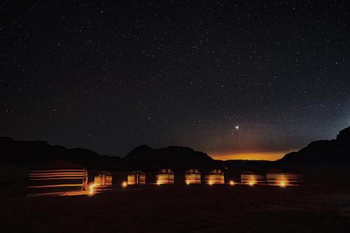 a starry night with a group of huts in the desert at Bedouin Nights Camp in Wadi Rum