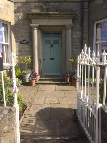 a blue front door of a house with a fence at Ellerton Lodge Bed and Breakfast Swaledale in Richmond