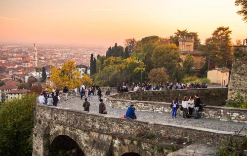 a group of people walking up a stone bridge at Green Stay Bergamo in Bergamo