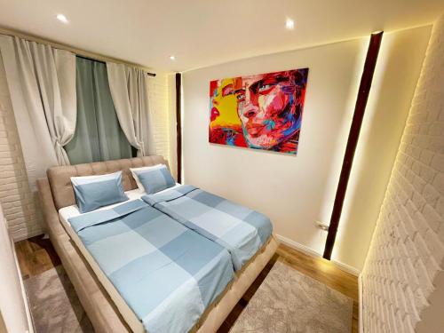 1 dormitorio con 1 cama con una pintura en la pared en Colorway Apartment en Belgrado