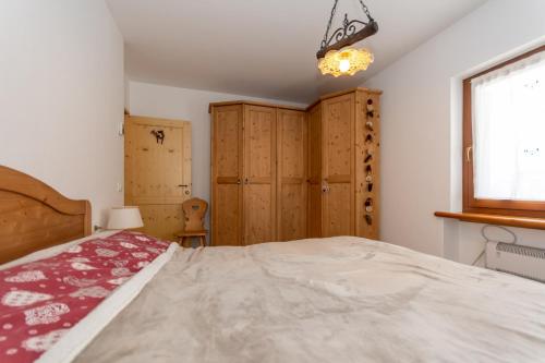 a bedroom with a bed and some wooden cabinets at Miralago in Alleghe