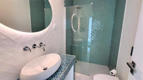 a white bathroom with a sink and a shower at The Shore @ Surf Paradise - Patio Terrasse in Espinho