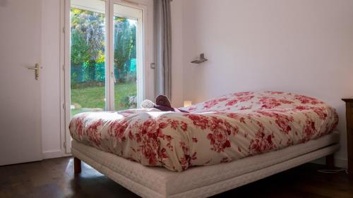 1 cama con edredón rojo y blanco y ventana en La Galante, en Meylan