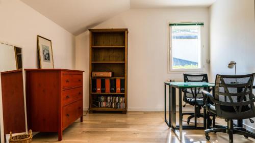 a room with a desk and chairs and a book shelf at La Galante in Meylan