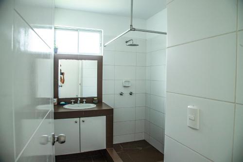 a white bathroom with a sink and a mirror at Condominio Nuevo Paracas in Paracas