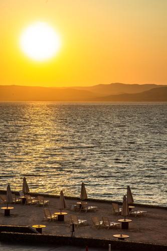 a group of tables and chairs on the beach at sunset at Condominio Nuevo Paracas in Paracas
