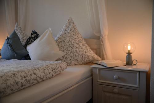 a bed with pillows and a candle on a night stand at Ferienwohnung Die Alte Schule in Daun