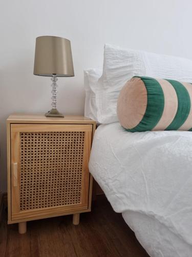 a bed with a night stand with a lamp on it at Be's Cottage in Malin Head