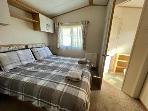 a bedroom with a bed with two towels on it at Willow Lodge in South Cerney