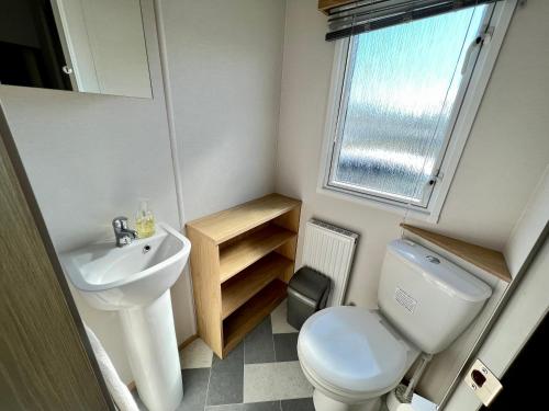 a small bathroom with a toilet and a sink at Willow Lodge in South Cerney