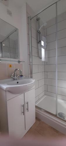 a bathroom with a sink and a shower and a tub at Woodland Retreat in Uny Lelant