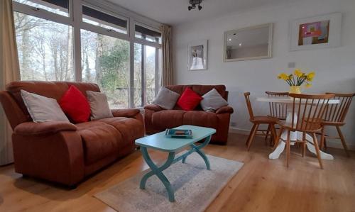 a living room with a couch and a table at Woodland Retreat in Uny Lelant