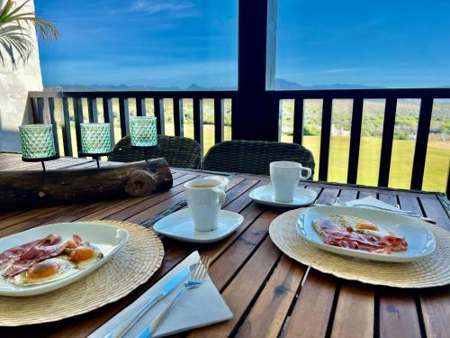 una mesa de madera con dos platos de comida. en Amazing Sea View La Hacienda Alcaidesa Links Golf Beach Resort, en Alcaidesa