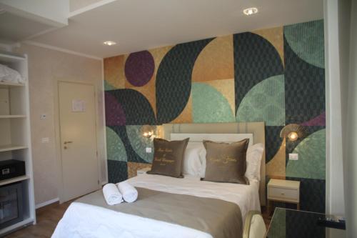 a bedroom with a bed and a colorful wall at Amsterdam Suite Hotel & SPA in Rimini
