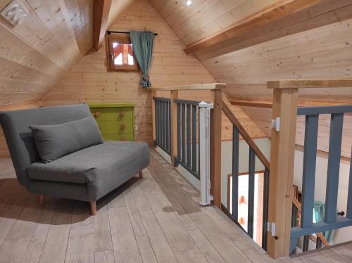 a living room with a chair in a cabin at Chalets "Ô Cœur des Puys" in Ceyssat