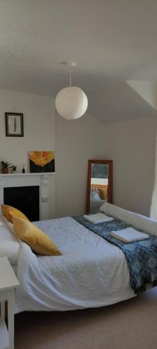 a bedroom with a large bed and a light fixture at Adail Cottage in Aberystwyth