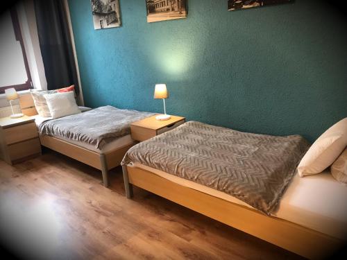 two beds in a room with a green wall at Alte Druckerei in Quedlinburg