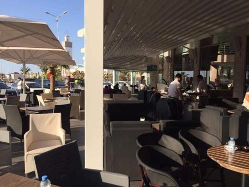 restauracja z białymi krzesłami i stołami oraz ludzie jedzący w obiekcie HOTEL BEAUTIFUL w mieście Nador