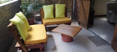 a porch with two chairs and a coffee table at Bois joli village in Le Marin