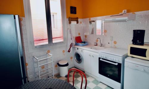 uma pequena cozinha com um lavatório e uma máquina de lavar roupa em Appartement 2 Les Clématites em Menton